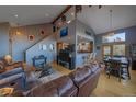 Sunlit living room with vaulted ceilings, wood floors, and seamless flow to the kitchen at 11222 Conifer Mountain Rd, Conifer, CO 80433