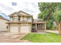 Charming two-story home with a well-manicured lawn, two-car garage and inviting front porch at 5185 E Weaver Dr, Centennial, CO 80121