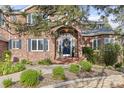 Close up view of the beautiful brick home entrance with a blue front door and landscaped garden at 5428 Golden Currant Way, Parker, CO 80134