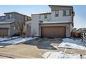 Two-story home showing its siding and garage with snow covered front lawn at 18012 E 107Th Ave, Commerce City, CO 80022