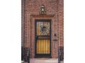 Inviting front door with decorative wreath, ornate security door and brick surround at 945 Niagara St, Denver, CO 80220