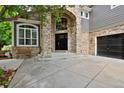 Inviting stone entrance with a black front door and an arched window above at 14075 Willow Wood Ct, Broomfield, CO 80020