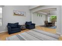 Bright living room with hardwood floors, blue chairs, and a view into the dining room at 14075 Willow Wood Ct, Broomfield, CO 80020