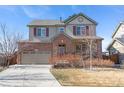 Two-story home featuring brick accents, neutral siding, well-kept landscaping, and an attached two-car garage at 129 N Irvington St, Aurora, CO 80018