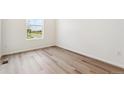 Bright bedroom featuring modern laminate flooring and a large window with neighborhood views at 9051 Telluride Ct, Commerce City, CO 80022