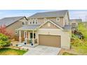Inviting exterior showcasing a covered front porch, lush green lawn, and a two-car garage, complemented by the mature landscaping at 12873 E 108Th Ave, Commerce City, CO 80022