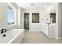 Bright bathroom features a soaking tub, double vanity, and a sleek glass-enclosed shower at 1672 Fox Trotter Pt, Castle Rock, CO 80104