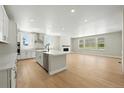 Modern open concept kitchen with stainless steel appliances, center island, and a cozy fireplace at 1672 Fox Trotter Pt, Castle Rock, CO 80104