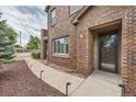 Inviting brick townhouse facade with walkway, garden area and a well-lit front entrance at 606 E Dry Creek Pl, Littleton, CO 80122