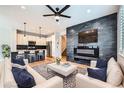 Stylish living room with modern fireplace, accent wall, and open-concept kitchen at 606 E Dry Creek Pl, Littleton, CO 80122