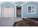 Close up of home entrance with a glass storm door, garage to the side, and rain gutters above at 1625 19Th Ave, Longmont, CO 80501