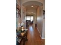 Inviting hallway featuring an archway and hardwood floors, creating a warm and welcoming entrance at 7851 E 148Th Dr, Thornton, CO 80602