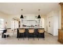 Modern kitchen with white cabinetry, a large island, and a marble countertop at 5700 S Steele St, Greenwood Village, CO 80121