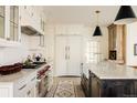 Bright kitchen showcasing white cabinetry, a marble countertop island, and stainless steel appliances at 5700 S Steele St, Greenwood Village, CO 80121
