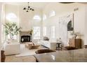 Open-concept living area with arched windows, fireplace, neutral decor, and view into the adjoining kitchen at 5700 S Steele St, Greenwood Village, CO 80121