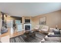 Comfortable living room featuring a fireplace, hardwood floors, neutral paint, and bright window at 5130 S Wenatchee St, Aurora, CO 80015