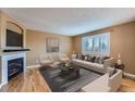 Cozy living room with a fireplace, neutral paint, hardwood floors, and bright window at 5130 S Wenatchee St, Aurora, CO 80015