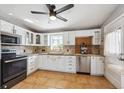 Bright kitchen featuring white cabinets, tile backsplash, stainless steel appliances, and tile flooring at 6690 Albion St, Commerce City, CO 80022