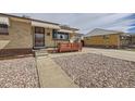 Street view showcasing the charming single-story brick home with gravel yard, awnings, and side driveway at 1328 S Zuni St, Denver, CO 80223