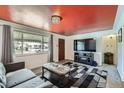 Inviting living room showcasing a modern rug, gray sofa, and a large window for natural light at 1328 S Zuni St, Denver, CO 80223