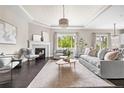 Elegant living room featuring a cozy fireplace, tray ceiling, and lots of natural light at 14303 Glenayre Cir, Parker, CO 80134