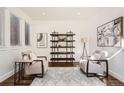 Comfortable living room featuring stylish decor, plush armchairs, and a decorative shelving unit at 2038 S Columbine St, Denver, CO 80210