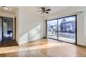 Sunlit living room with hardwood floors, a ceiling fan, and sliding glass doors at 11676 Josephine Cir, Thornton, CO 80233