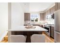 Kitchen island with white countertop and two light beige chairs at 2828 N Federal Blvd, Denver, CO 80211