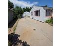 Back of the house and detached garage, connected by a wide driveway and chain-link gate at 475 Tennyson St, Denver, CO 80204