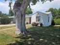Cozy home with a mature shade tree, well-maintained lawn, and vibrant flowers at 475 Tennyson St, Denver, CO 80204