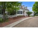 Charming two-story white home featuring black shutters, a brick walkway, and a basketball hoop at 8721 E 23Rd Ave, Denver, CO 80238