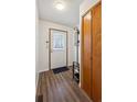 Cozy entryway featuring wood-look flooring, a coat rack, and a bright, welcoming door at 11923 E Ford Dr, Aurora, CO 80012