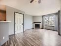 Living room with light grey walls, wood flooring, a fireplace, and natural light at 5745 W Atlantic Pl # 207, Lakewood, CO 80227
