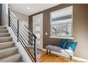 Bright entryway with hardwood floors, a modern staircase, and a comfortable bench seat at 2122 S Ogden St, Denver, CO 80210