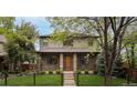 Inviting two-story home with a brick facade, a well-kept lawn, and fresh landscaping at 1927 S Grant St, Denver, CO 80210