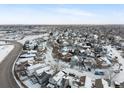 Winter aerial view of a residential neighborhood with snow-covered houses and streets at 12061 Ivy Way, Brighton, CO 80602