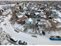 Aerial view of snow-covered residential neighborhood featuring well-maintained homes and tree-lined streets at 12061 Ivy Way, Brighton, CO 80602