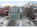 Inviting two-story home with an attached garage, manicured lawn, and classic architectural details at 12061 Ivy Way, Brighton, CO 80602