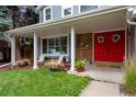 Inviting front porch with red double doors and white columns at 10399 Zenobia Ct, Westminster, CO 80031