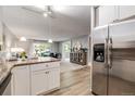 Open kitchen with stainless steel refrigerator, modern countertops, and adjacent living area at 710 S Clinton St # 3A, Denver, CO 80247