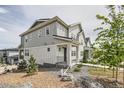 Two-story home featuring gray siding, landscaped front yard, and inviting walkway at 8822 Fraser River Loop, Littleton, CO 80125