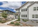 Charming two-story home featuring white siding, landscaped front yard, and inviting walkway at 8822 Fraser River Loop, Littleton, CO 80125