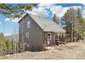 Charming exterior elevation showing the house nestled among the trees at 11390 Shimley Rd, Golden, CO 80403