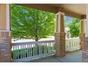 A charming front porch with brick pillars and a view of a mature shade tree at 2741 Poplar Grove Pl, Castle Rock, CO 80109