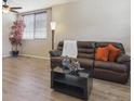 Open-concept living area with wood floors, a comfy sofa, and decorative accents at 3978 Aspen Hollow Ct, Castle Rock, CO 80104