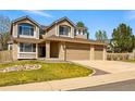 Attractive two-story home with a spacious three-car garage and green lawn at 19061 E Powers Pl, Aurora, CO 80015