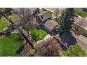 Aerial shot of a private backyard with a stone patio, mature trees, lush green lawn and perimeter fencing at 12155 W 68Th Pl, Arvada, CO 80004