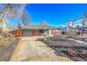 View of the home's exterior, including a covered carport and a low maintenance yard at 5442 S Cedar St, Littleton, CO 80120