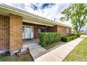 Inviting front entrance with a decorative storm door and manicured hedges at 41020 Us Highway 36, Bennett, CO 80102
