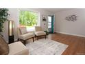Cozy living room featuring hardwood floors, a large window, and stylish decor at 10420 Marion St, Northglenn, CO 80233